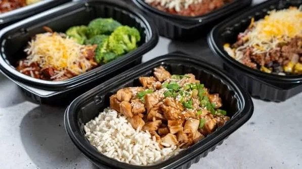 Clean Eatz meals in black containers with rice and chicken